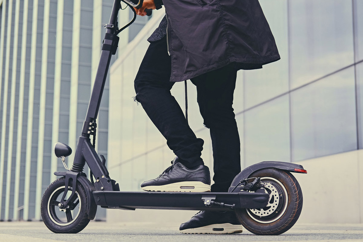 Close up image of a man on an electric scooter.